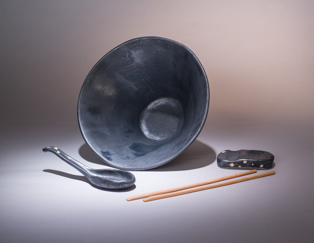 bol à ramens en porcelaine, modelé à la plaque, émaillé en noir mat anthracite avec sa cuillère et son repose-baguette et cuillère, collection Sakura, motif fait en retenu à la cire, création Atelier Tōkinari, pour illustrer la page revendeur, collaboration avec Atelier Tōkinari